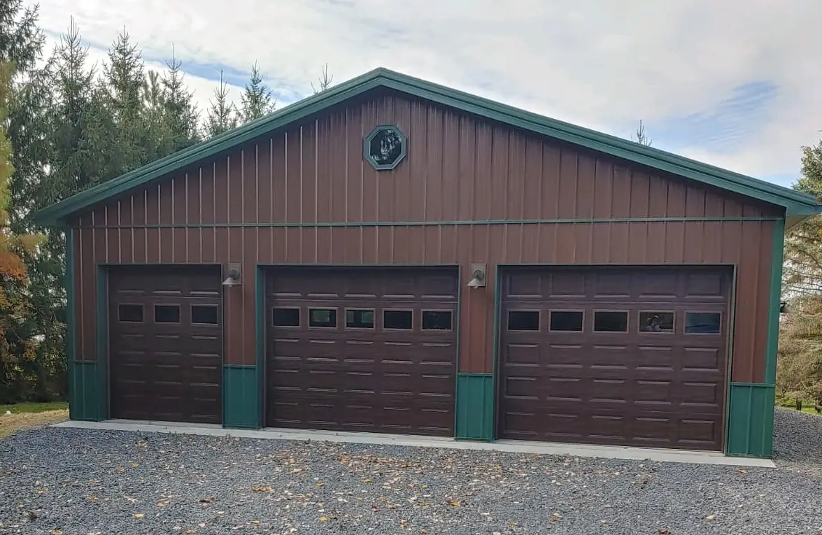 Brown and green three-car garage pole barn